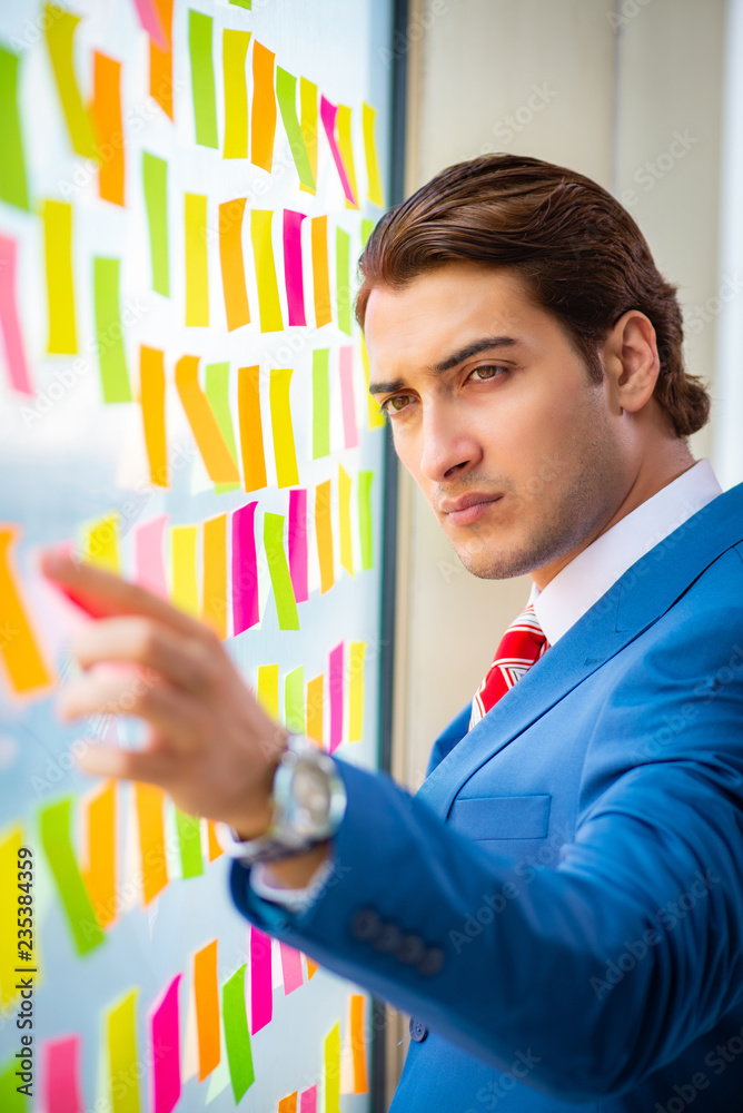 Young handsome employee with many conflicting priorities   