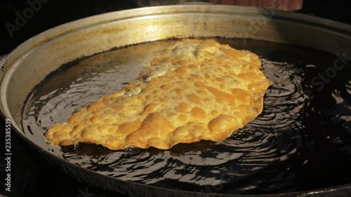 Process cooking national Buryat Mongolian dish cheburek. Big large xxxl 68cm heburek fry with cheese meat onions into cooking pot in oil. Fried flatbread piadina naan pita tortilla shelpek cheburek. photo