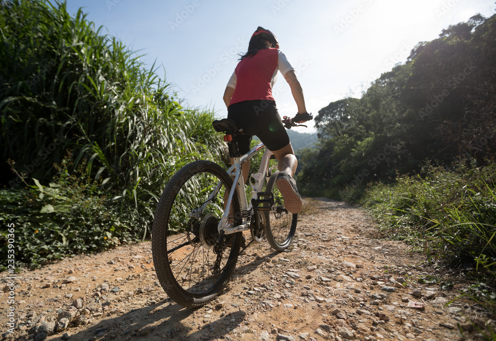 Fototapeta premium Woman ccyclist riding a bike on a nature trail in the mountains.people living a healthy lifestyle