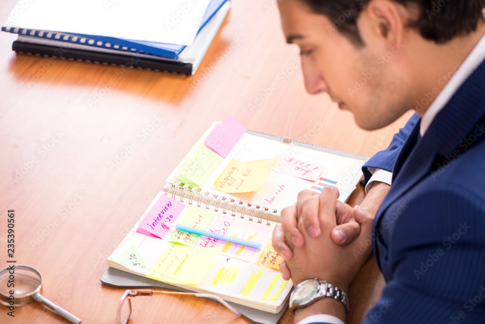 Young handsome employee planning his work activity Young handsome employee planning his work activity