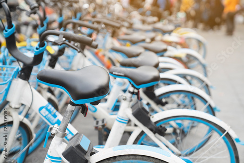 Bicycle rental service on city road parking with sunlight, public transportation concept.