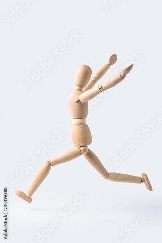 running wooden mannequin isolated on white background