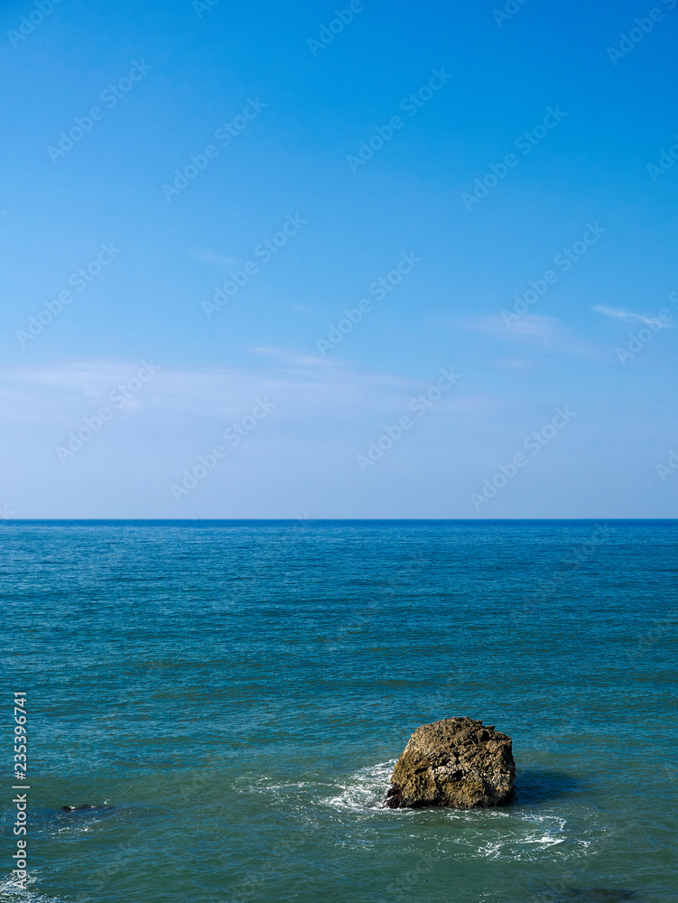 Rock in azure water - ocean horizon split - seascape Rock in azure water - ocean horizon split - seascape