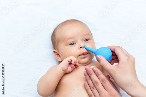 mother cleaning the nose of a newborn with a clyster