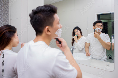 Young couple doing morning habit in bathroom