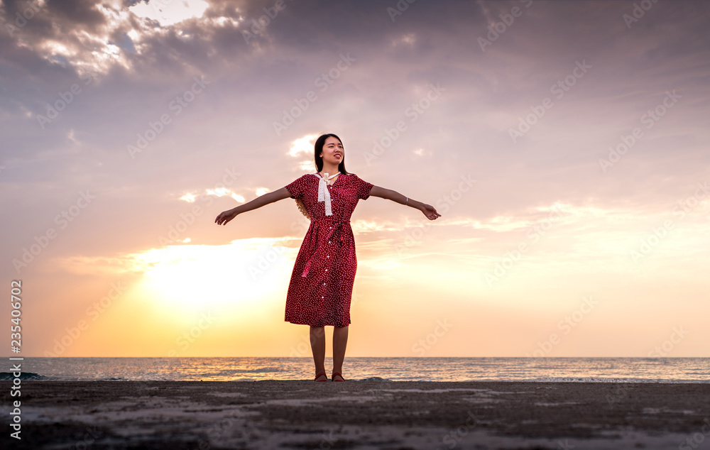 Fototapeta premium Woman enjoying romantic sunset at the beach