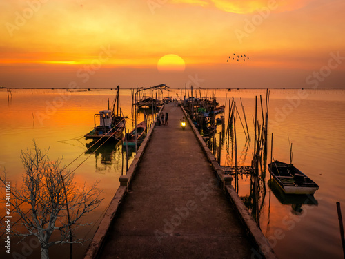 The beautiful landscape of Bangsaen(Thailand) sea port with fishery boat on golden light sunset.