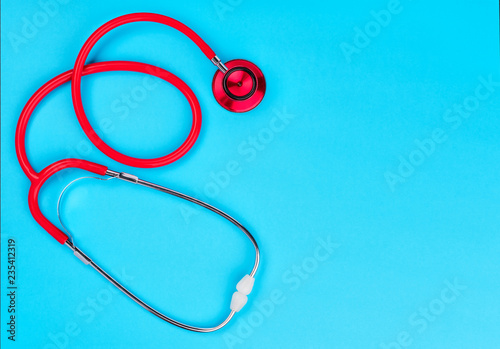 Stethoscope on blue background with copy space for text. Top view