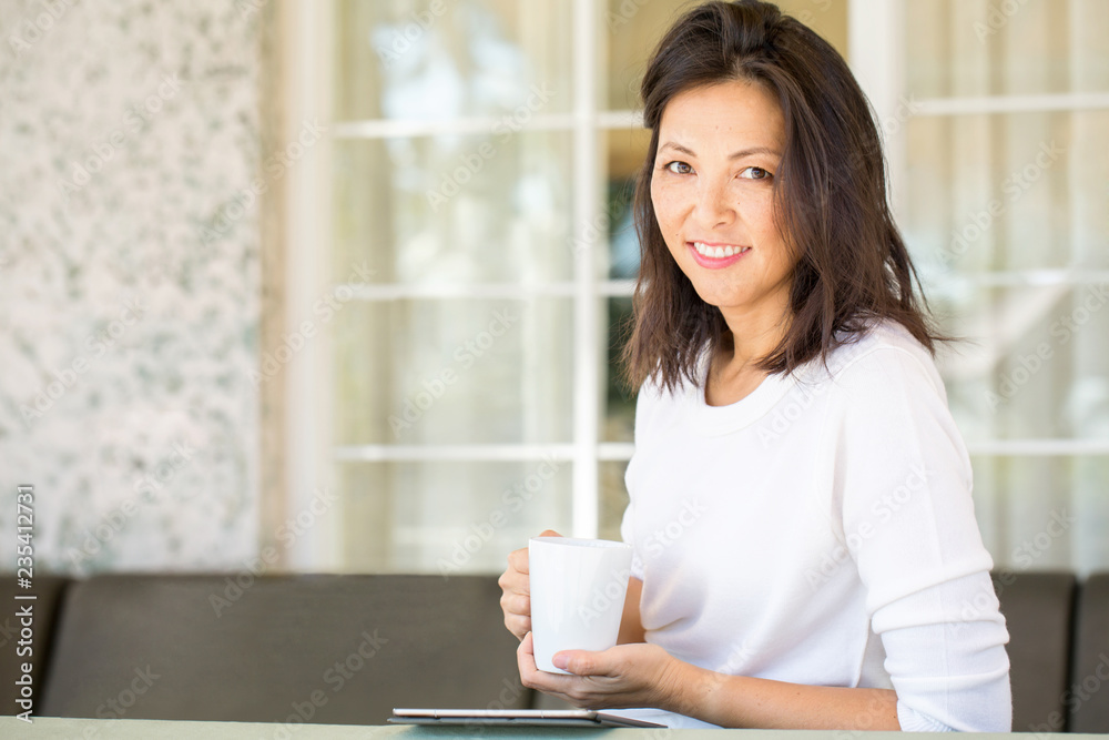 Portrait of an Asian woman smiling and drinking coffee. Portrait of an Asian woman smiling and drinking coffee.