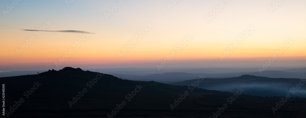 Stunning sunset silhouette landscape image of Foggintor in Dartmoor
