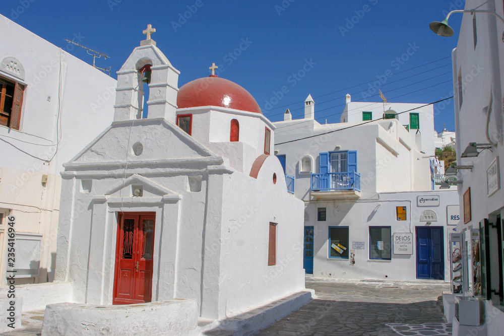 White Church with a Red Dome set against the beautiful blue skies of Mykonos, Greece