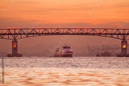 Traffic on bridge and sea crossing Mactan Bridge Cebu in misty dusk and sunset at golden hour 