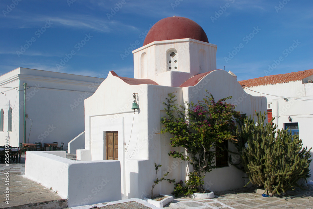 White Church with a Red Dome set against the beautiful blue skies of Mykonos, Greece