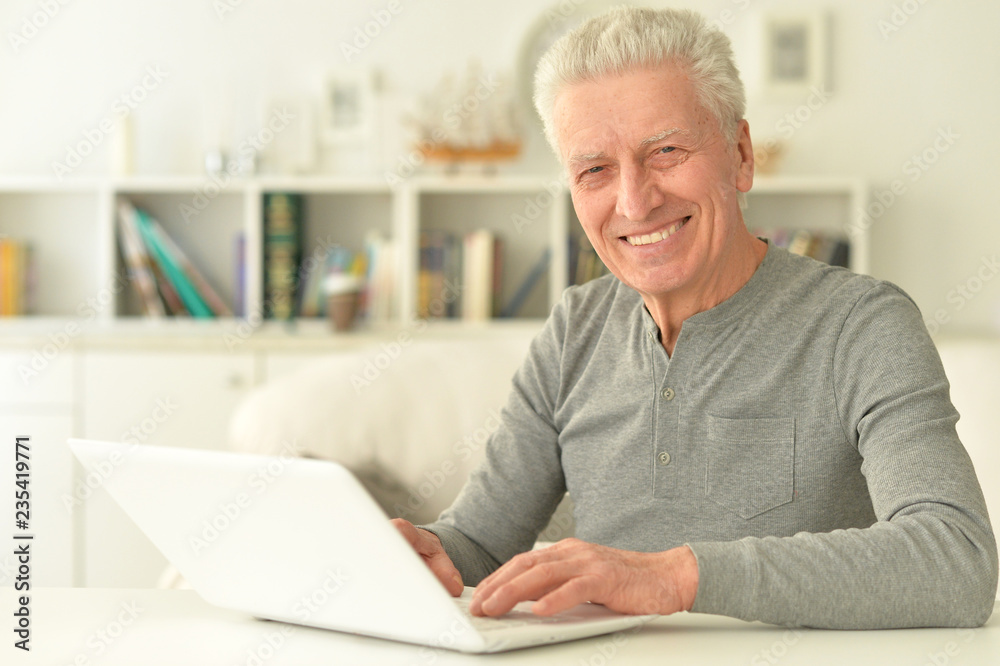 Portrait of happy senior man using laptop Portrait of happy senior man using laptop