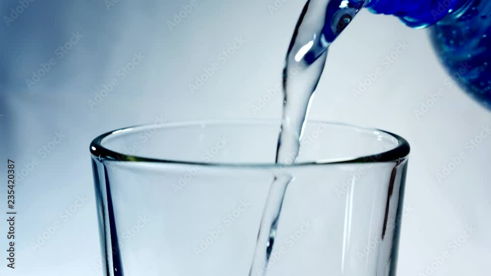 Mineral water from the bottle is poured into a glass. Pure living water.