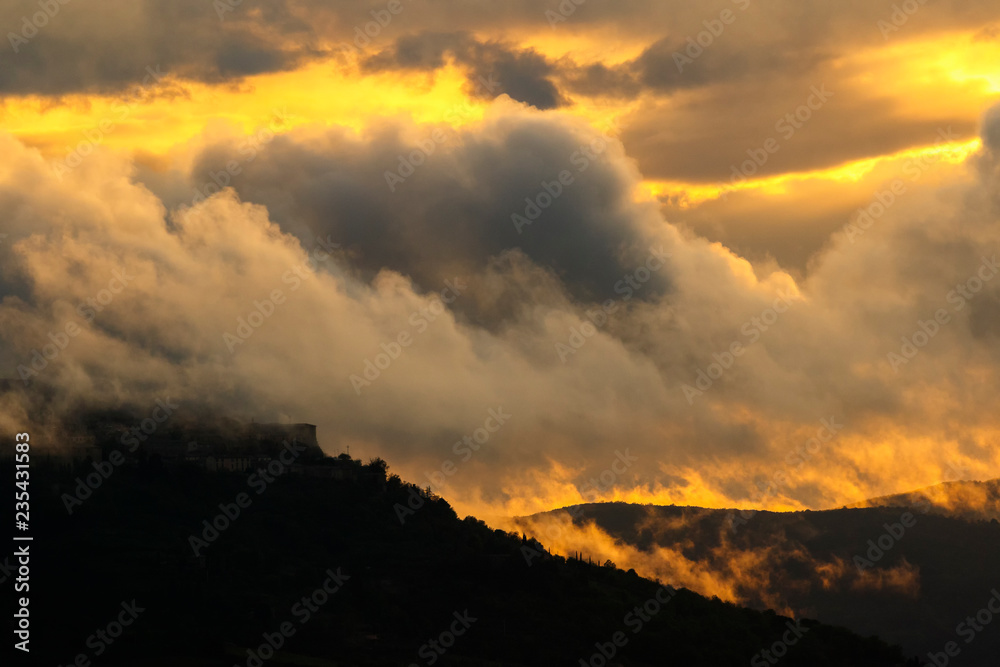Heavy clouds in a sunset with mountains in silhouette