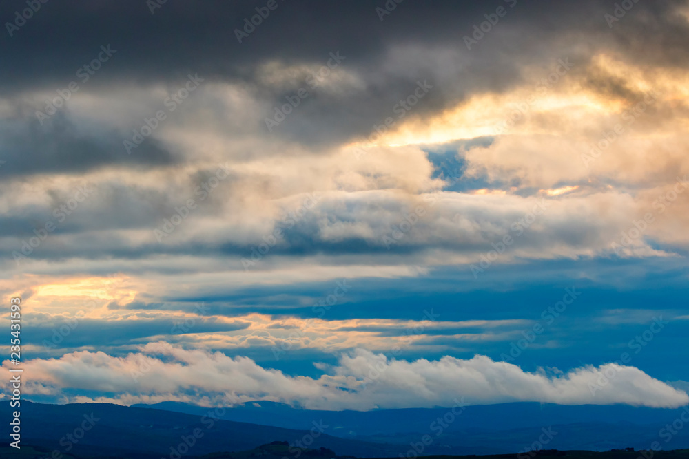 Cloudscape view over a rolling landscape at dusk