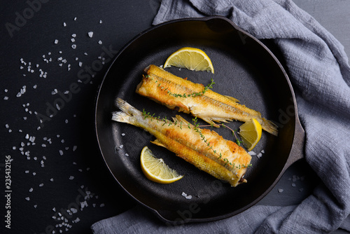 Photography Top view of smelt fish on frying pan with lemon