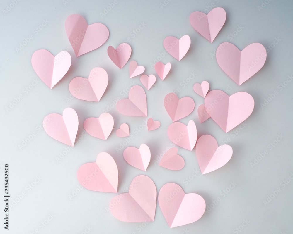 Pink paper hearts placed on white background.
