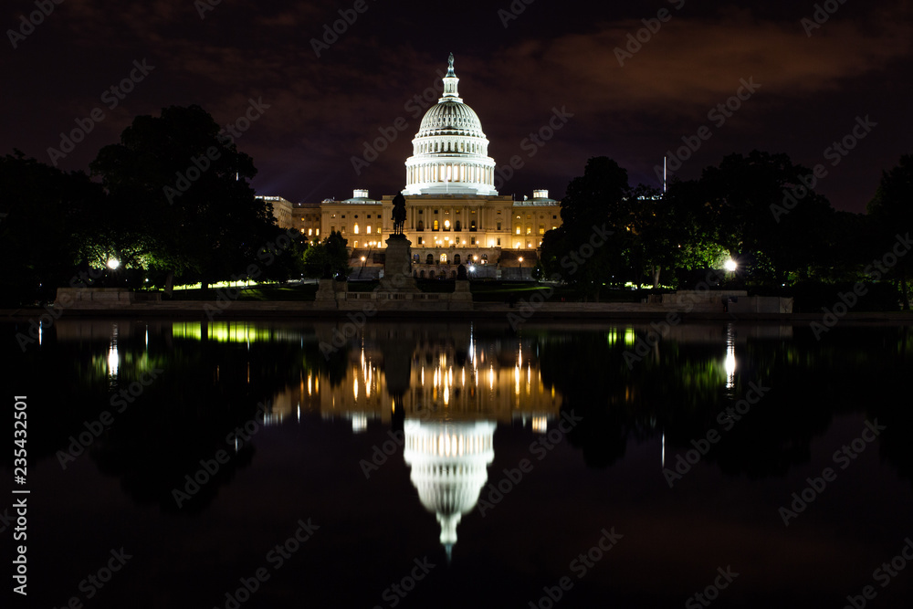 United state capitol reflecting in the pool by night illuminated by  the street lights in washington DC