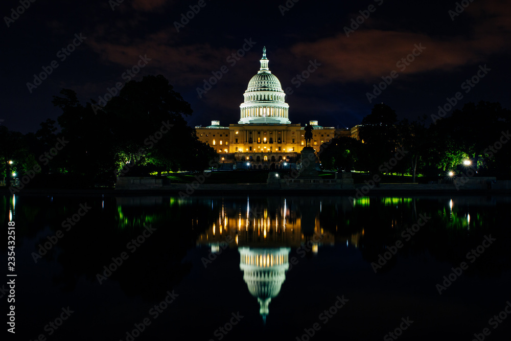 United state capitol reflecting in the pool by night illuminated by  the street lights in washington DC