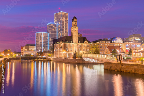 Evening cityscape of Malmo, Sweden. Modern and old historical buildings reflected in the water. Picturesque sunset in a city