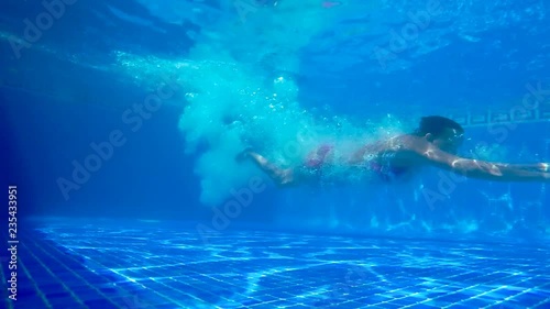 Young girl jumping into the pool.