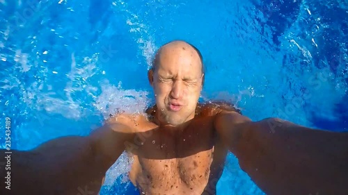 Young man jumps in the pool.