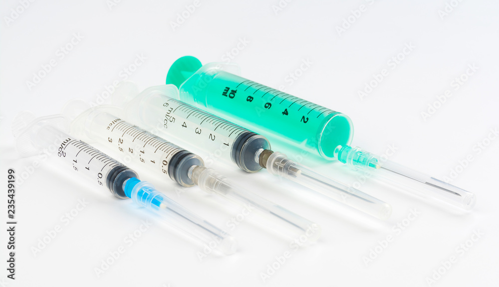 A set of disposable syringes for injections of different sizes on a white background. A set of disposable syringes for injections of different sizes on a white background.