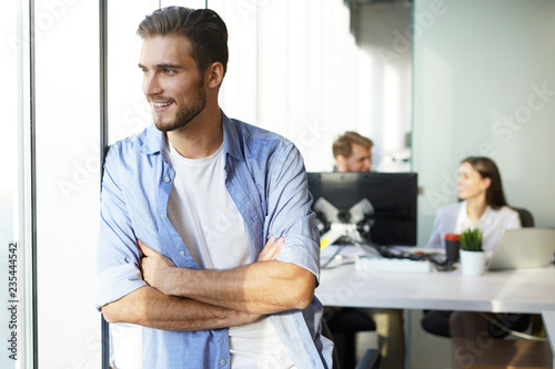 Portrait of a happy young casual businessman at office  smiling.