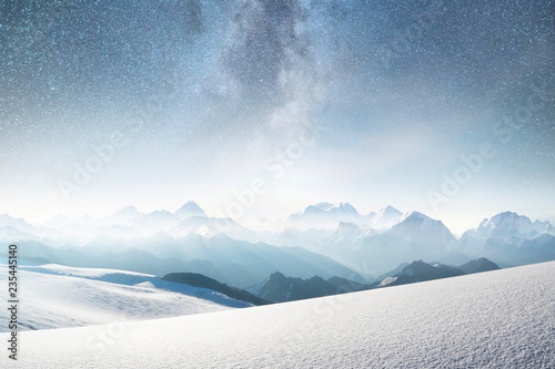 Mountains and sky with stars. Natural landscape in mountains region at the winter time. Starry sky and high peak.