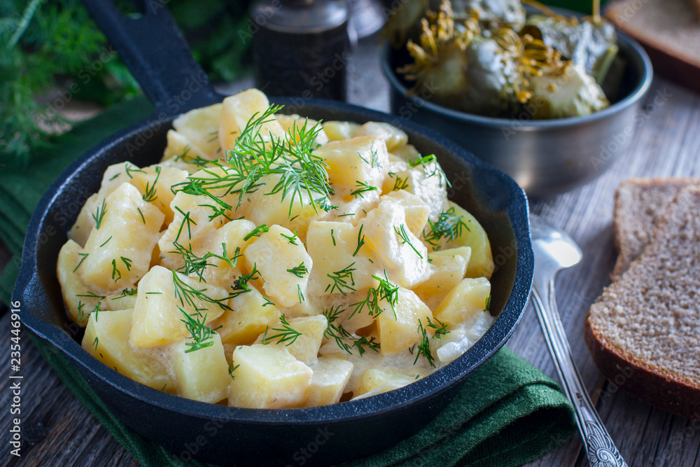 young potatoes cooked in sour cream in a cast iron pan, horizontal