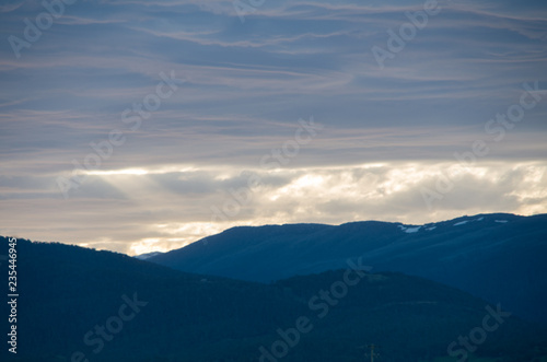 Soft Fluffy clouds near sunset over mountains