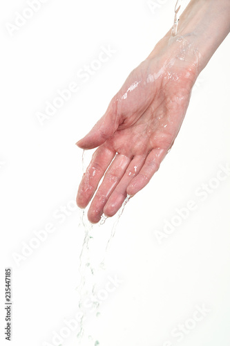 On the female hand runs clear water. Isolated on white background. 