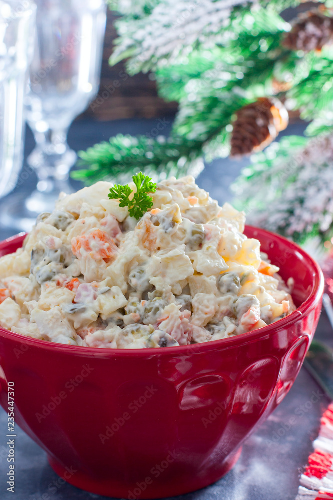 Traditional Russian New Year's salad in a red bowl with New Year's decor, selective focus Traditional Russian New Year's salad in a red bowl with New Year's decor, selective focus
