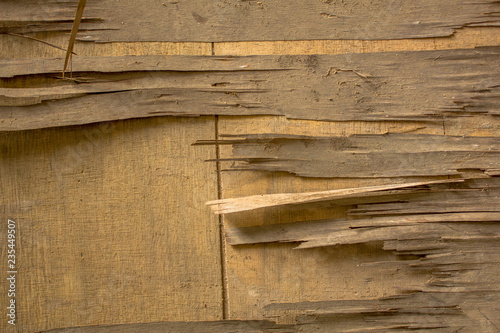Old dirty broken light yellow plywood on a wooden surface. wooden texture.