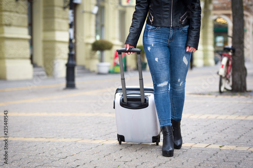 young tourist woman with her baggage on street in winter