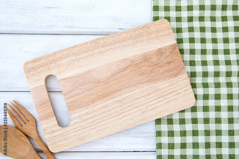  a chopping board and tablecloth with wooden fork and spoon on white table , recipes food  for healthy habits shot note background concept