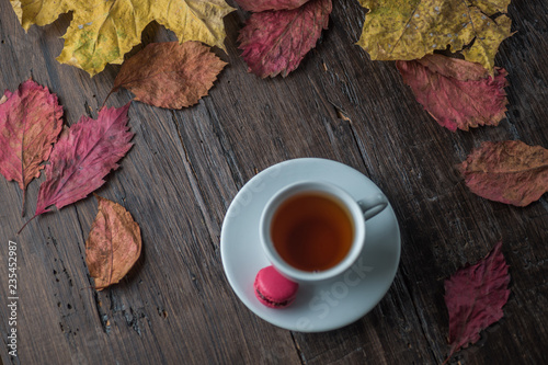 Autumn still life of colorful leaves, a Cup of tea, on an old brown wooden table