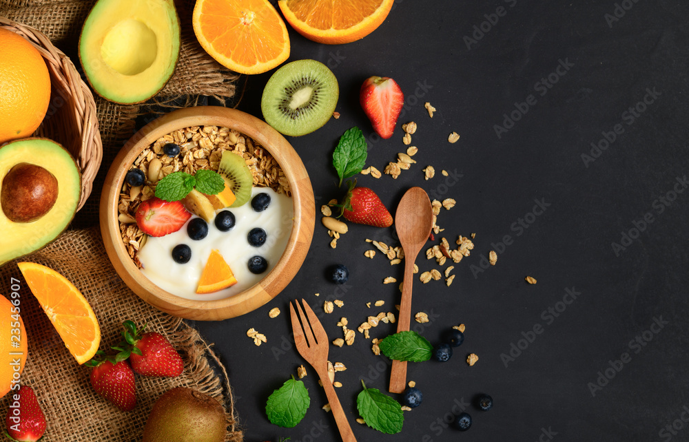 Granola and yogurt with fruits in wood bowl