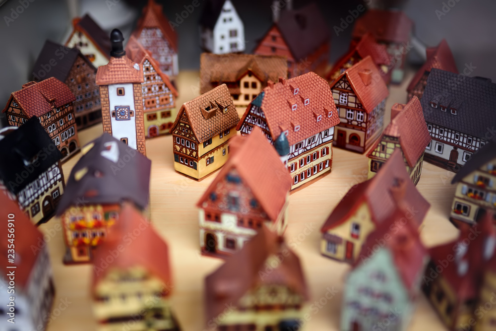 Naklejka premium Decorative ceramic houses candle holders on the shelf of Christmas marketplace.