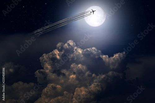 Jet plane and contrail on the background of the full moon