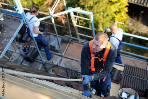 Dachdecker bei Instandhaltungsarbeiten: Sicherheitsgurt nach Vorschrift anlegen und nutzen, Unfälle vermeiden photo