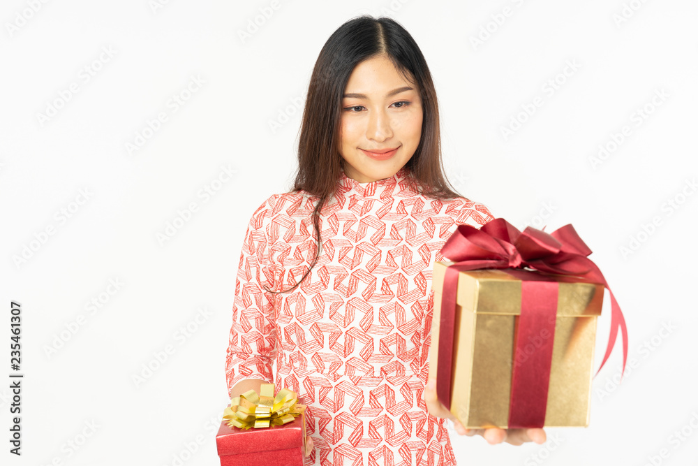 Photo of asian curious woman in red dress rejoicing her birthday or new year gift box. Young woman holding gift box with red bow being excited and surprised holiday present isolated white background Photo of asian curious woman in red dress rejoicing her birthday or new year gift box. Young woman holding gift box with red bow being excited and surprised holiday present isolated white background