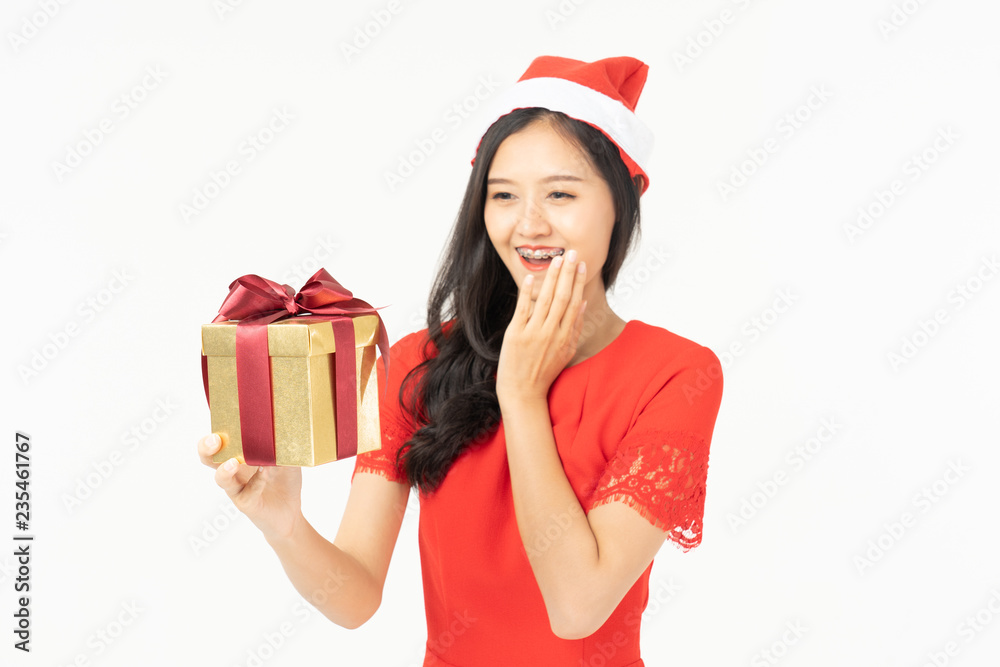 Photo of asian curious woman in red dress rejoicing her birthday or new year gift box. Young woman holding gift box with red bow being excited and surprised holiday present isolated white background Photo of asian curious woman in red dress rejoicing her birthday or new year gift box. Young woman holding gift box with red bow being excited and surprised holiday present isolated white background
