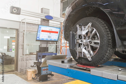 A Car on the Car Steering Wheel Balancer and Calibrate with laser reflector attach on each tire to center driving adjust in the garage