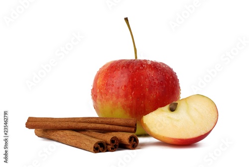  Red ripe apple and aromatic cinnamon sticks on white background