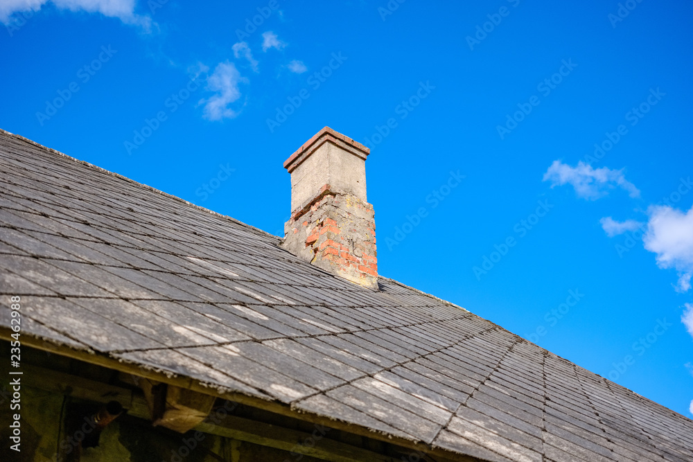 country house roof top with chimney on blue sky
