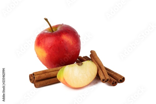  Red ripe apple and aromatic cinnamon sticks on white background
