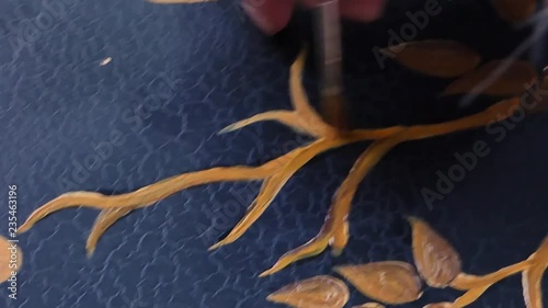 painter decorator draws and cover with varnish of picture, close-up, macro shooting